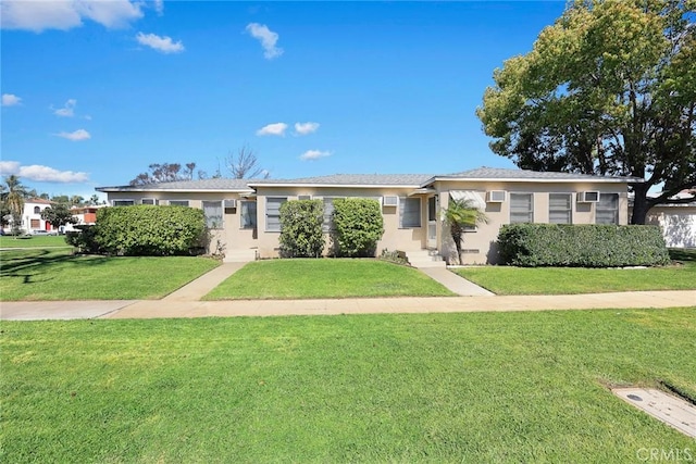 ranch-style home with a front yard and stucco siding