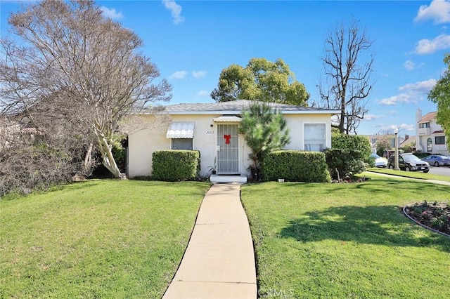 ranch-style home with a front lawn and stucco siding