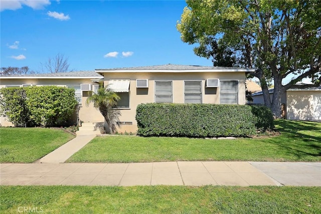 bungalow-style home featuring a front lawn and stucco siding