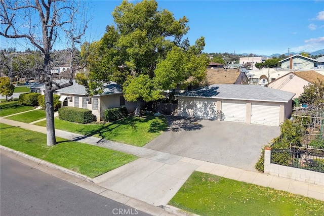 single story home with aphalt driveway, a garage, fence, a residential view, and a front lawn