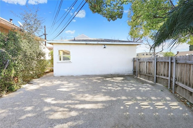 back of house with fence and stucco siding