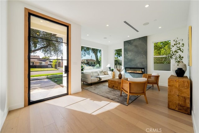 living area with light wood finished floors, a fireplace, visible vents, and recessed lighting