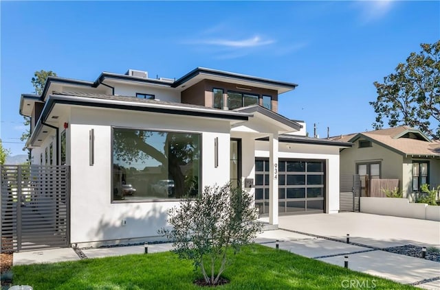 prairie-style home with an attached garage, concrete driveway, and stucco siding