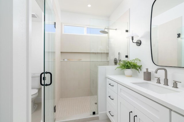 bathroom featuring toilet, a stall shower, and vanity