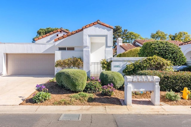 mediterranean / spanish house with a garage, concrete driveway, and stucco siding