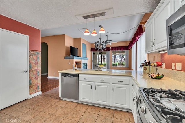 kitchen with light tile patterned floors, appliances with stainless steel finishes, light countertops, and a sink