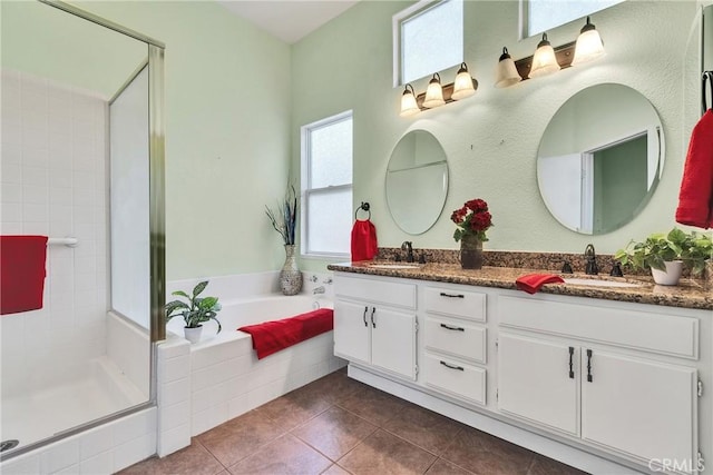 bathroom with a bath, tile patterned floors, a stall shower, and a sink