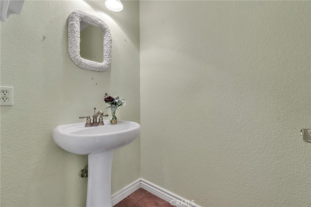 bathroom with baseboards and tile patterned flooring