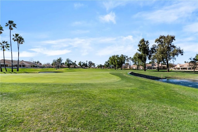 surrounding community with view of golf course and a lawn