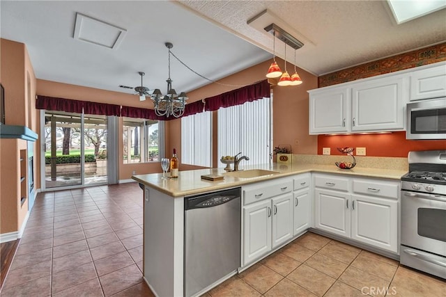 kitchen with a sink, stainless steel appliances, an inviting chandelier, and light countertops