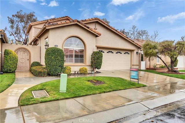 mediterranean / spanish-style home featuring a front lawn, concrete driveway, a tile roof, stucco siding, and a garage