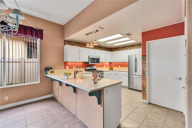 kitchen with visible vents, light tile patterned floors, a peninsula, white cabinets, and stainless steel appliances