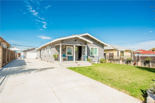 view of front of home featuring a porch, fence, and a front lawn