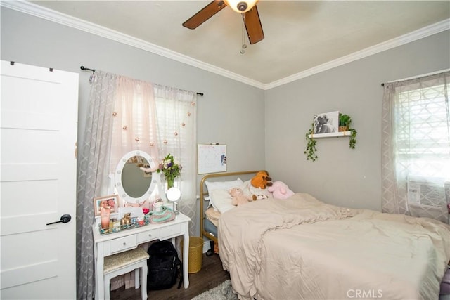 bedroom featuring ornamental molding, a ceiling fan, multiple windows, and wood finished floors