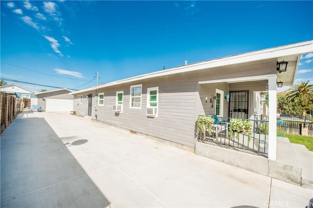 exterior space with a detached garage, fence, and cooling unit