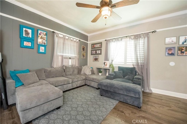 living area featuring ceiling fan, ornamental molding, wood finished floors, and baseboards