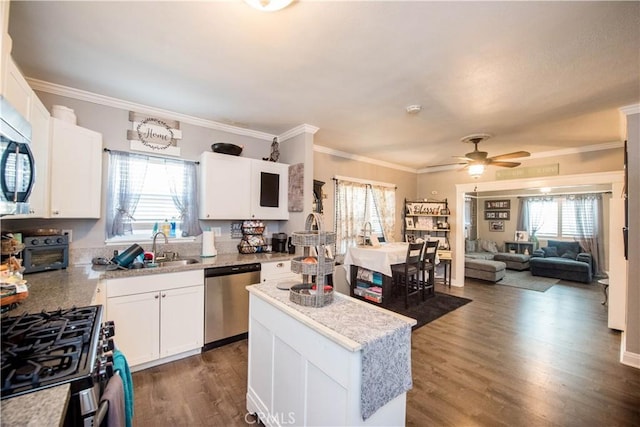 kitchen with dark wood-type flooring, a wealth of natural light, dishwasher, and a sink