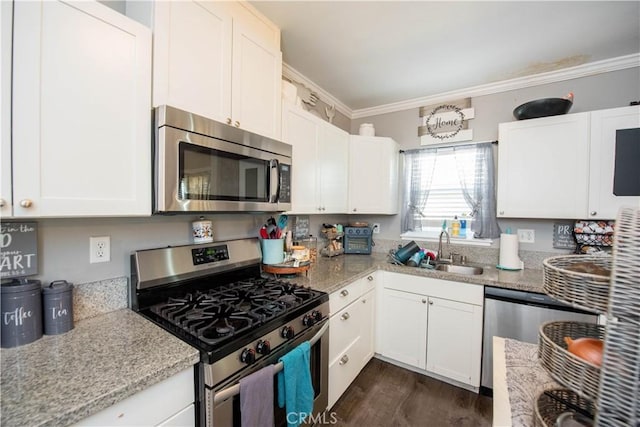 kitchen featuring light stone counters, crown molding, stainless steel appliances, white cabinets, and a sink