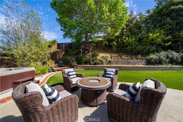 view of patio / terrace with a hot tub, an outdoor fire pit, and a fenced backyard