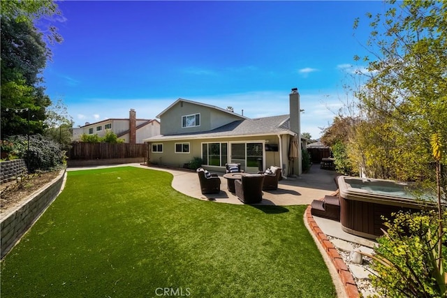 rear view of property with a hot tub, a patio area, a fenced backyard, and a lawn