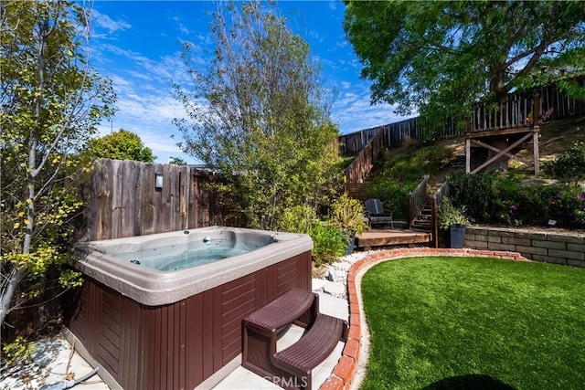view of yard with a hot tub, stairway, and a fenced backyard