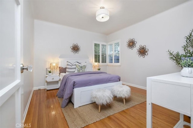 bedroom with light wood-type flooring and baseboards