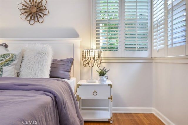 bedroom with wood finished floors and baseboards