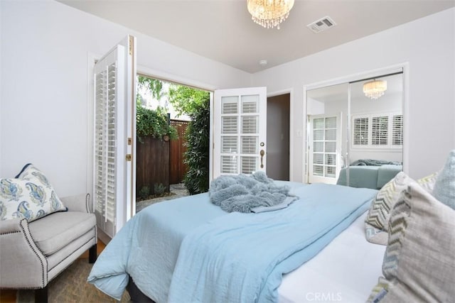 bedroom with access to outside, visible vents, and an inviting chandelier