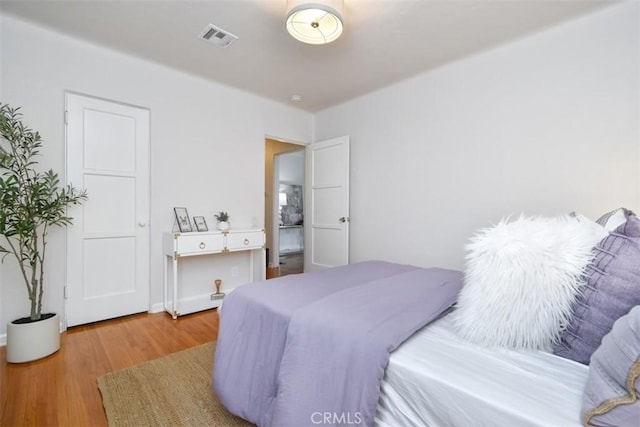 bedroom featuring wood finished floors and visible vents