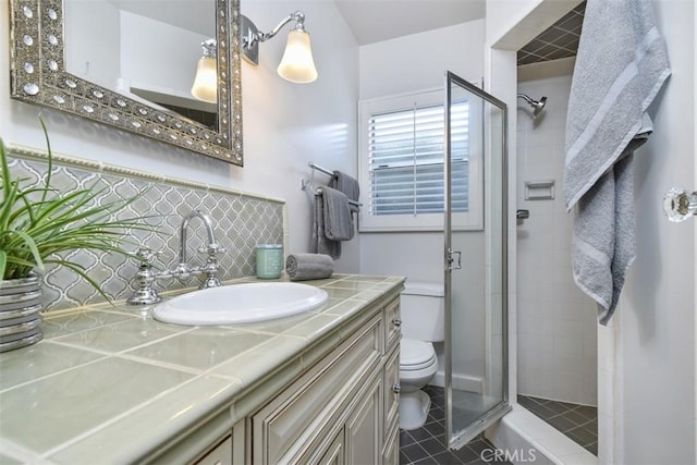 full bathroom with tile patterned flooring, toilet, vanity, backsplash, and a shower stall