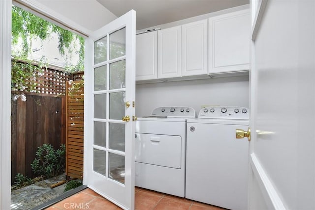 laundry area with cabinet space, washing machine and clothes dryer, and light tile patterned floors