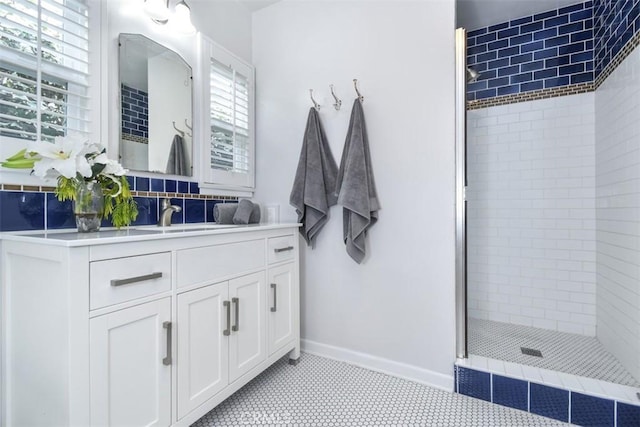 bathroom featuring a shower stall, vanity, and baseboards