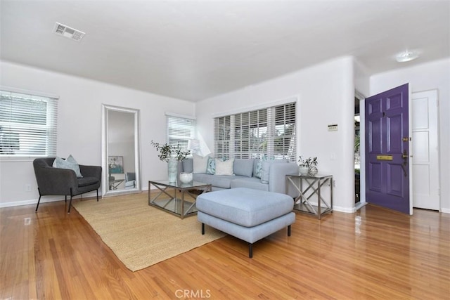 living room with a wealth of natural light, light wood-style flooring, and visible vents