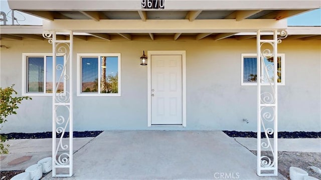 entrance to property featuring stucco siding