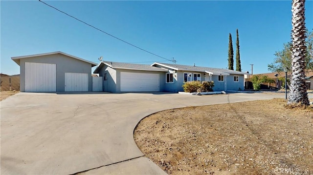 ranch-style house with concrete driveway, an attached garage, and stucco siding