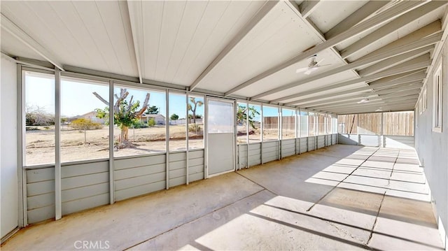 unfurnished sunroom featuring ceiling fan and a wealth of natural light