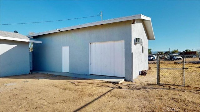 view of outbuilding with a gate, fence, and an outdoor structure