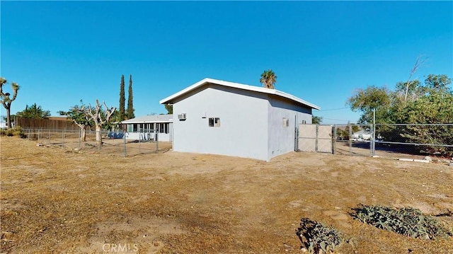 rear view of property featuring fence and stucco siding