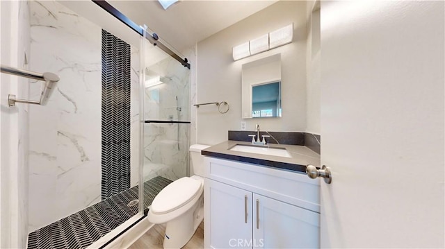 full bath featuring vanity, a marble finish shower, and toilet