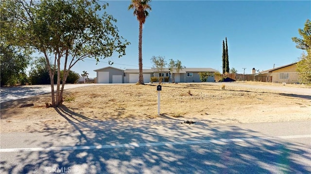 single story home featuring a garage and fence