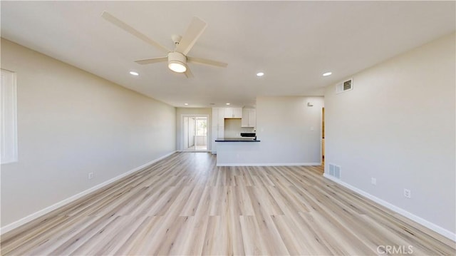 unfurnished living room with a ceiling fan, baseboards, visible vents, and light wood finished floors