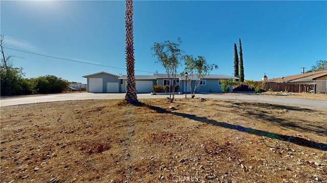 ranch-style home featuring fence and driveway