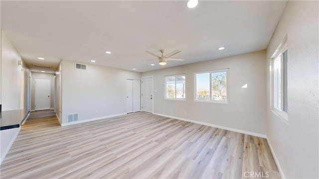 unfurnished room with light wood finished floors, baseboards, and visible vents