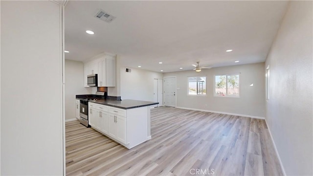 kitchen featuring white cabinets, dark countertops, visible vents, and stainless steel appliances