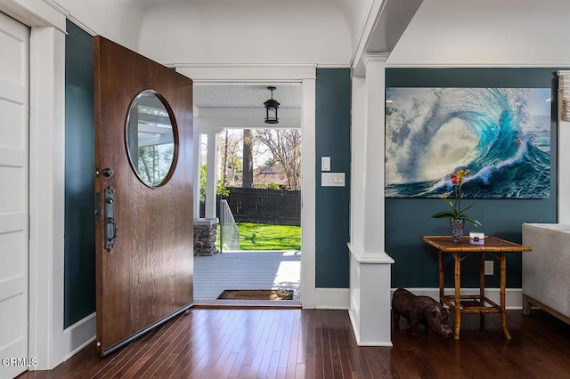 entrance foyer featuring ornate columns, wood finished floors, and baseboards