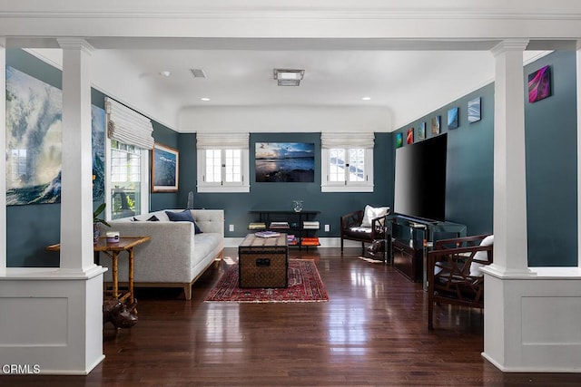 living room featuring ornamental molding, baseboards, ornate columns, and wood finished floors