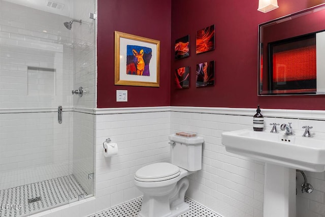 bathroom featuring wainscoting, visible vents, and a shower stall