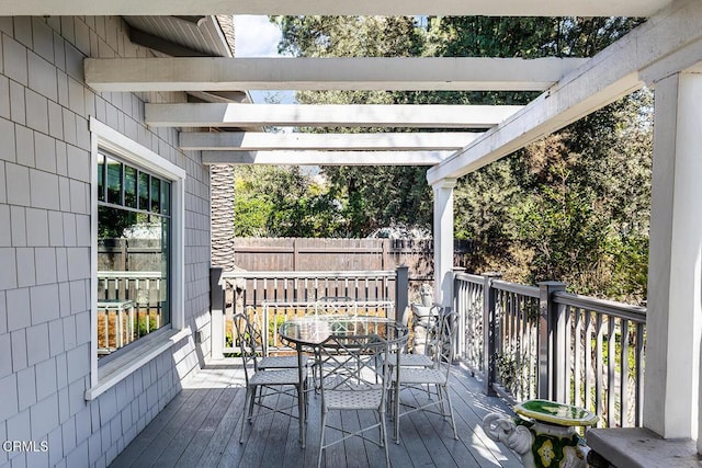 deck with outdoor dining space, fence, and a pergola