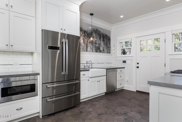 kitchen with stainless steel appliances, a wealth of natural light, a sink, and decorative backsplash