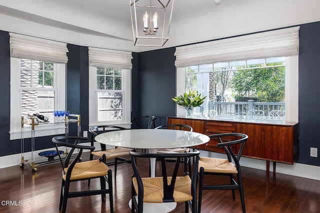 dining area with a notable chandelier, baseboards, and hardwood / wood-style flooring